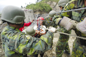 13日，臺灣高雄縣六龜鄉(xiāng)新開村有20多戶遭泥石流淹沒。圖為軍人正陸續(xù)將生還者救出。