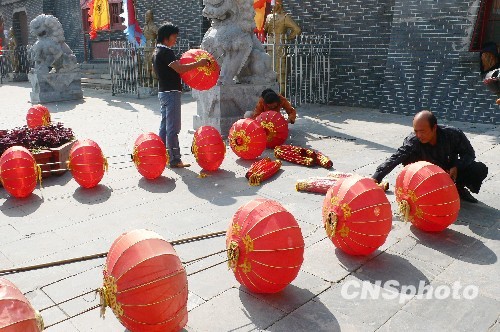 8月31日，河南省開封市天波楊府門口，工作人員在準(zhǔn)備懸掛大紅燈籠。隨著“十一”國慶節(jié)和“十一”旅游黃金周的臨近，古城開封的公園景點已早早開始備戰(zhàn)，營造喜慶祥和的旅游環(huán)境，迎接八方客人。 中新社發(fā) 李俊生 攝