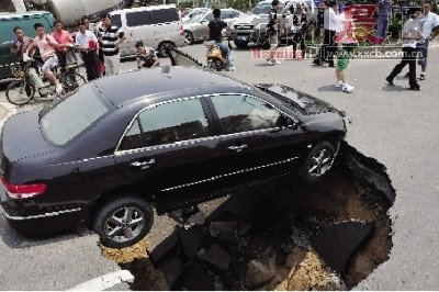 4日，南昌市昌南大道與迎賓北大道交叉口附近路面突然發(fā)生塌陷，一輛過路小轎車被卡在洞口處。圖/新華社