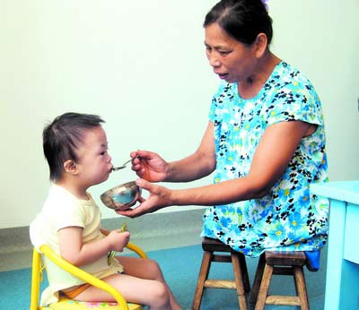 許月華在給孩子喂飯。劉炬 攝