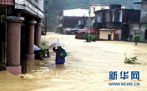 10月21日，臺(tái)灣宜蘭縣蘇澳地區(qū)居民在洪水中艱難出行。新華社發(fā) 