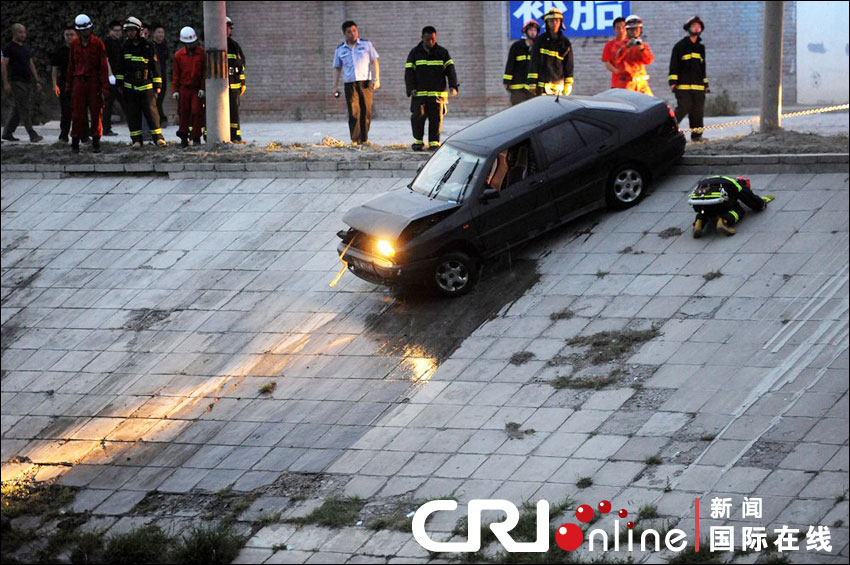 2012年6月17日下午，北京四元橋下方的西壩河輔路上，一輛轎車失控墜河中。消防員將轎車拖上岸。