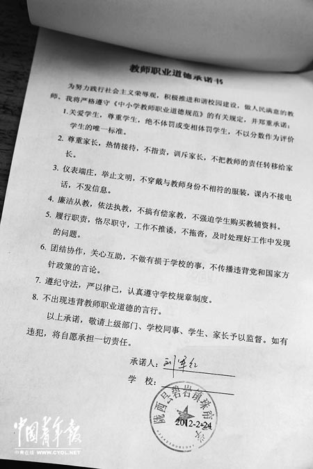 劉軍紅簽字的教師職業(yè)道德承諾書。本報(bào)記者 張鵬攝