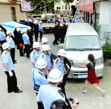 青島彪悍女揮斧頭菜刀阻強(qiáng)拆 城管站一排舉盾牌