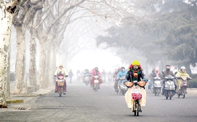 昨天上午，中原路，行人在霧霾中騎車出行，很多行人戴上了口罩。