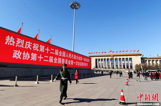 3月4日，北京晴空萬里，武警從北京天安門廣場大型顯示屏前走過。3月5日上午，十二屆全國人大一次會議將隆重開幕。中新社發(fā) 劉忠俊 攝